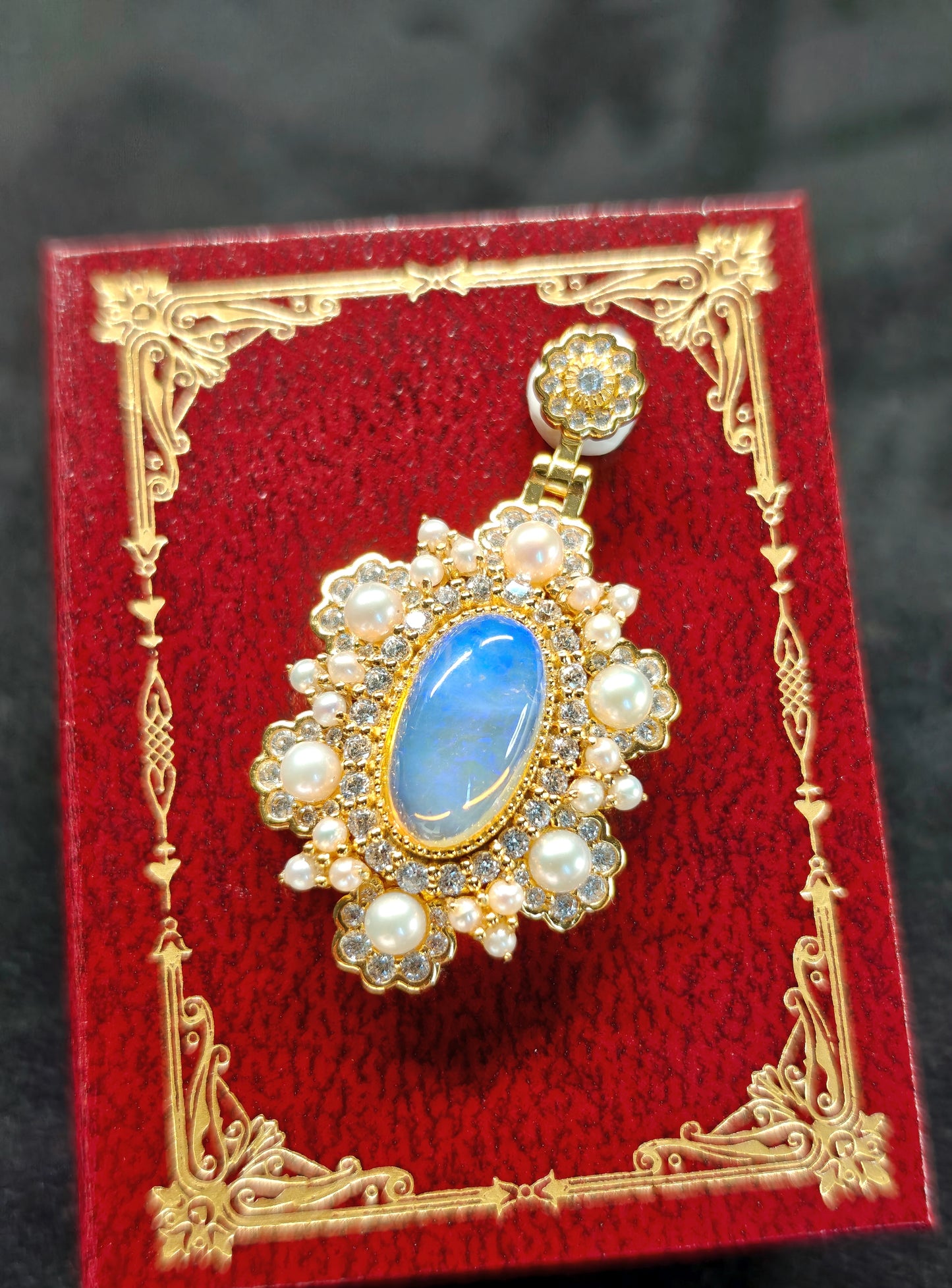 Vintage-style pendant featuring a large central blue crystal opal surrounded by pearls 