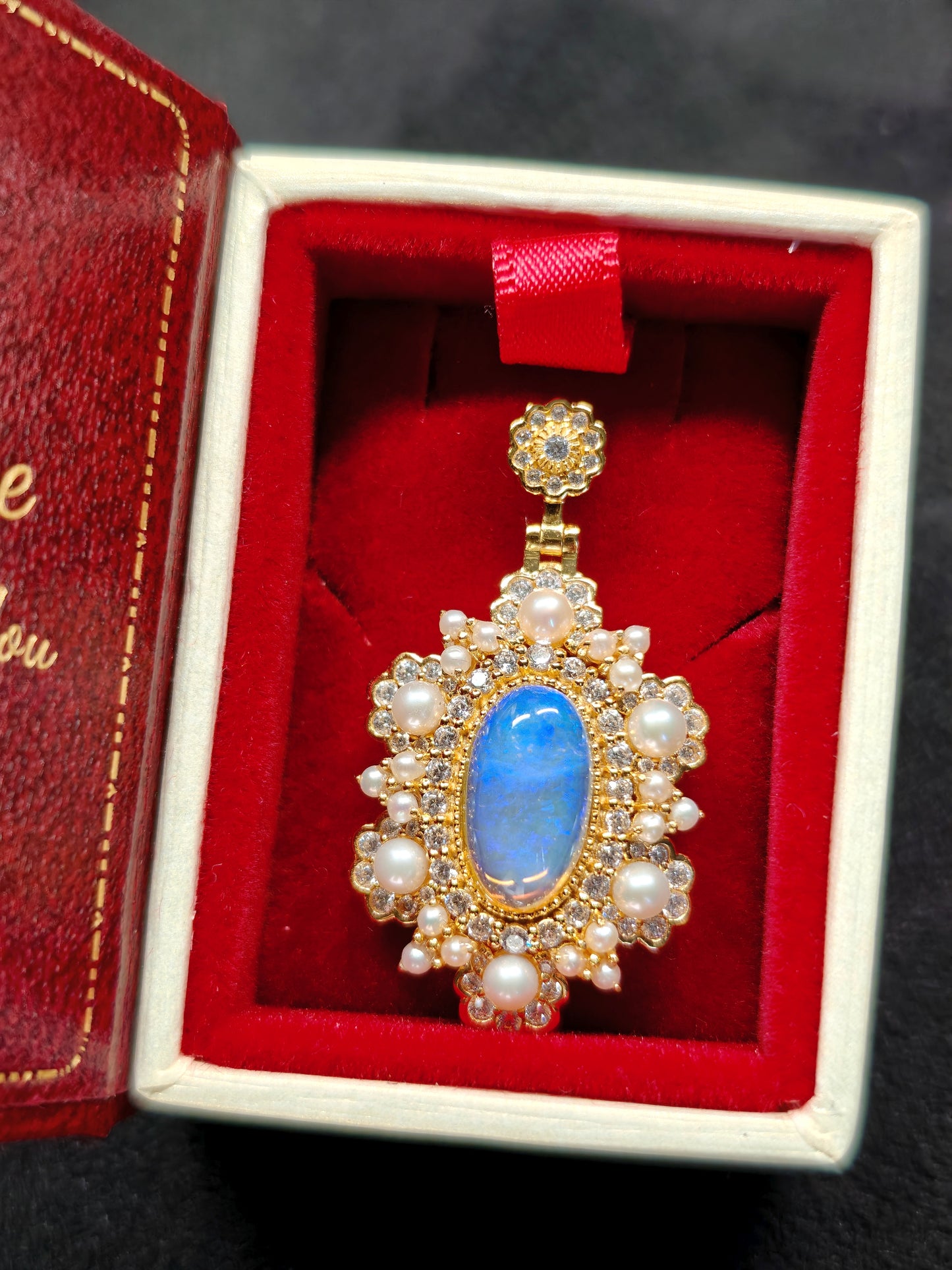 Vintage-style pendant featuring a large central blue crystal opal surrounded by pearls 