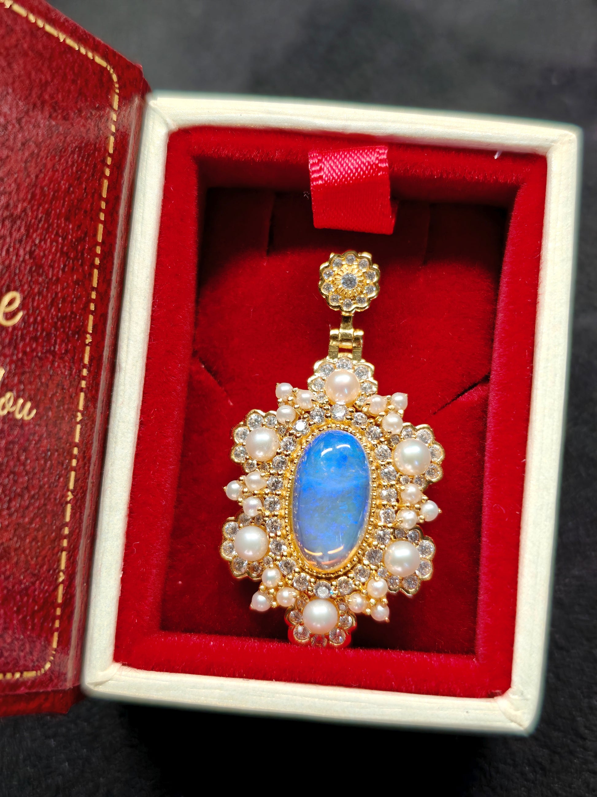 Vintage-style pendant featuring a large central blue crystal opal surrounded by pearls 