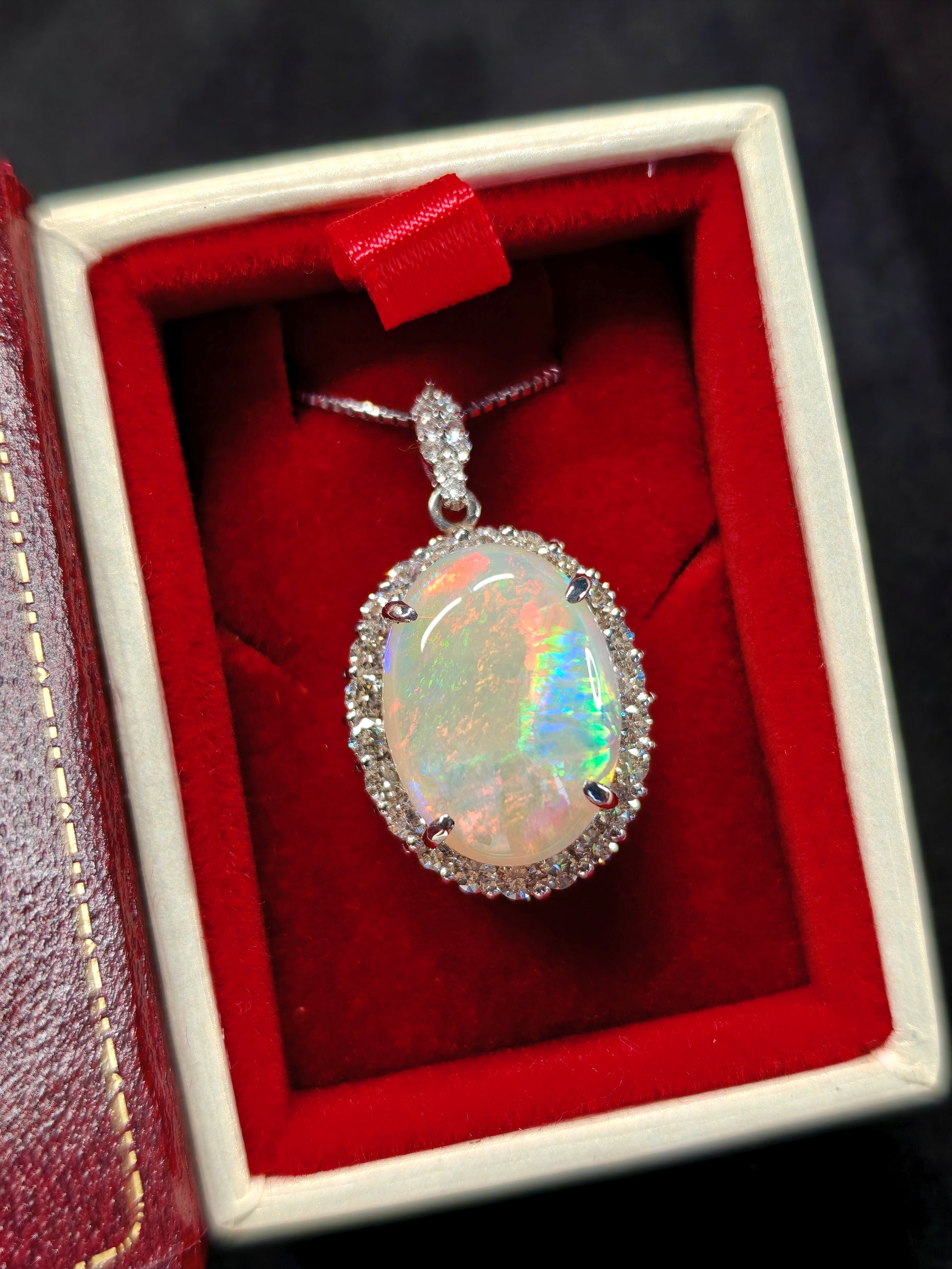 Oval crystal opal and diamond halo pendant with diamonds